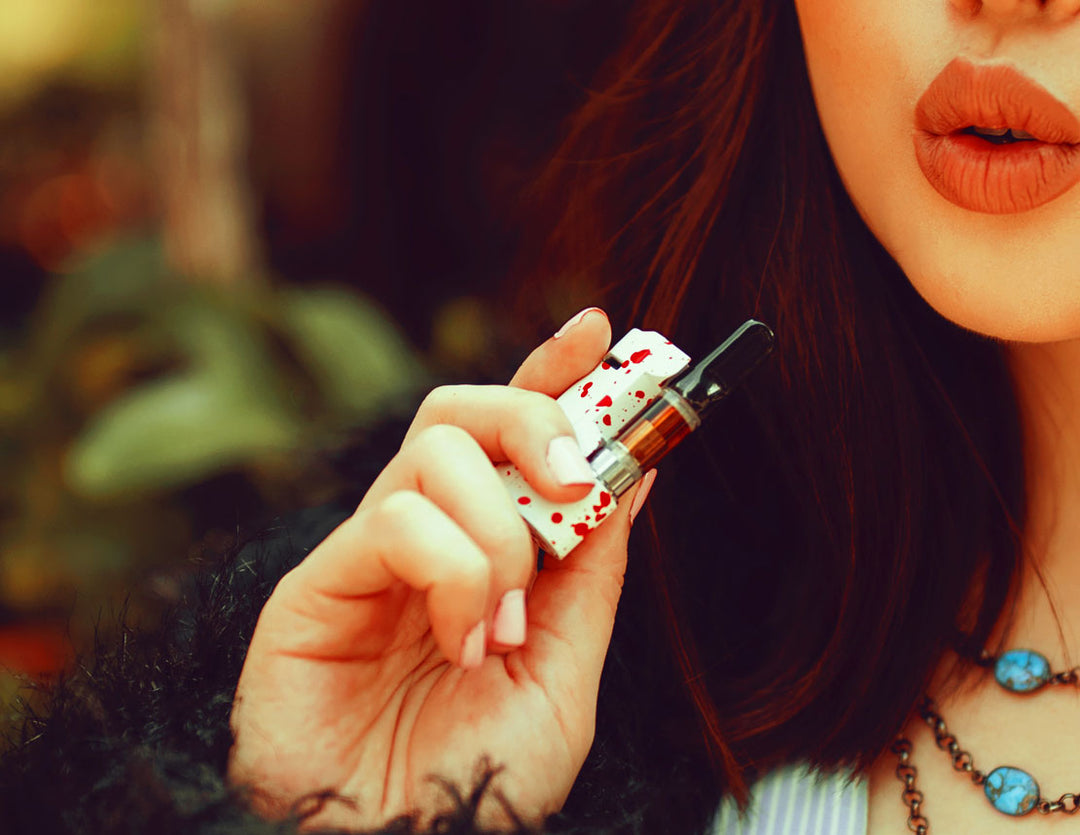 Woman in fur coat about to puff Wulf Micro Plus in front of park background