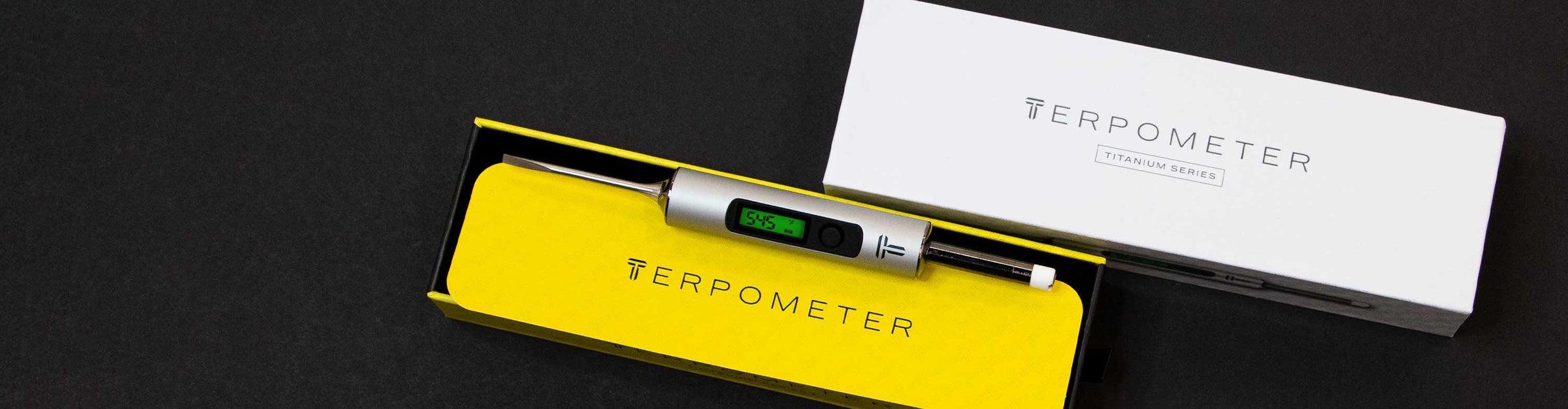Terpometer Digital Thermometer laying down with packaging on black background