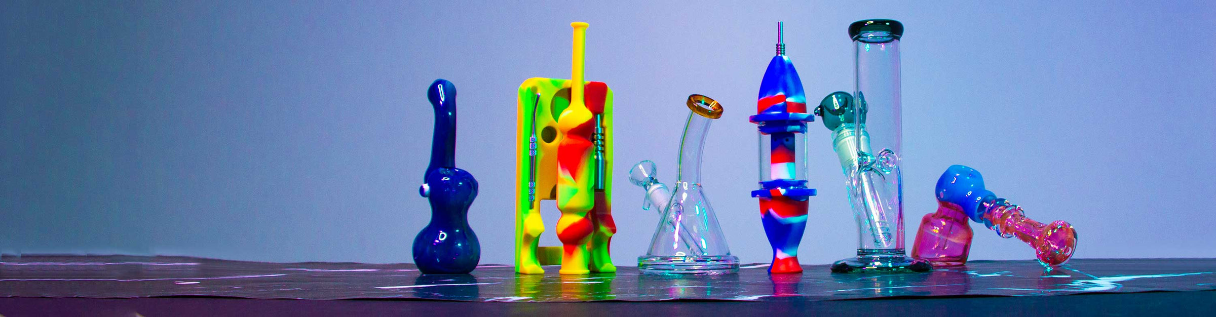 Got Vape Retail Glass and Silicone products standing on marble textured table inside studio with blue and purple lighting