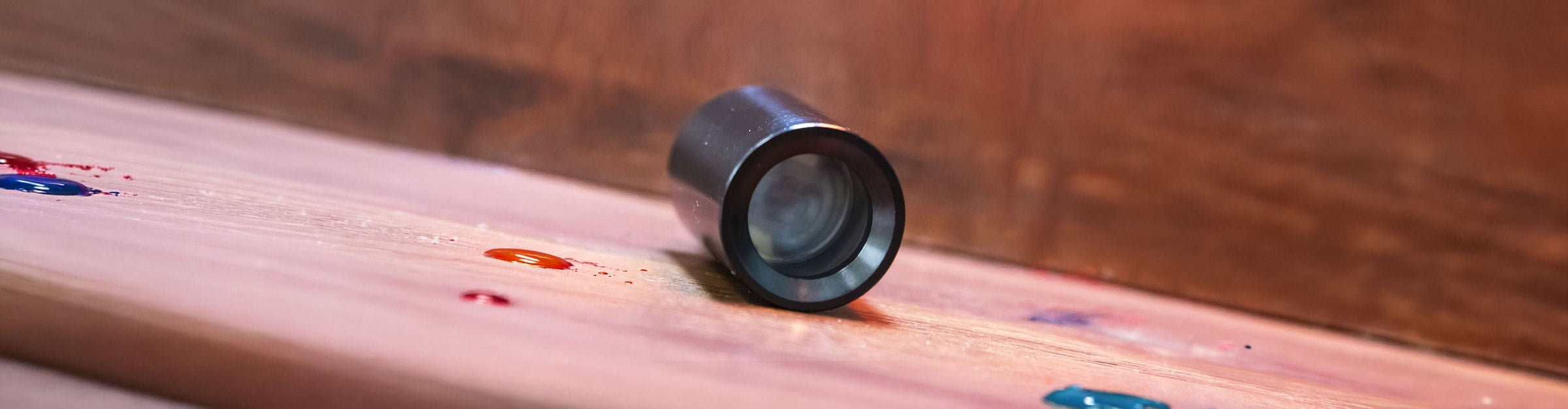 Exxus Go Plus on wooden surface with paint splatters