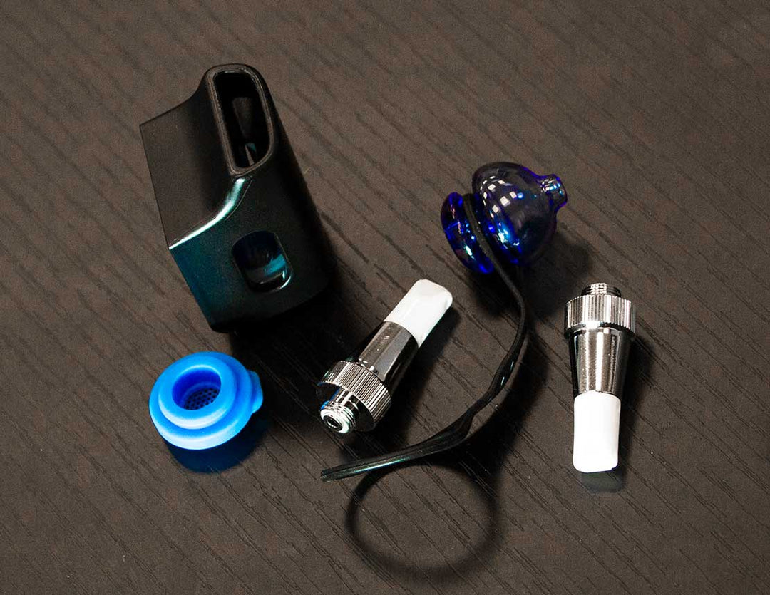 Vaping Accessories laying down on black wooden table inside office building.